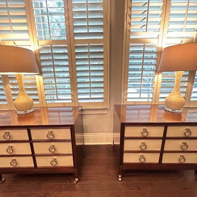 Sale Photo Thumbnail #100: Pair of modern campaign-style nightstands with light-colored drawer fronts, ring pulls, and caster feet, topped with matching textured gourd table lamps.
