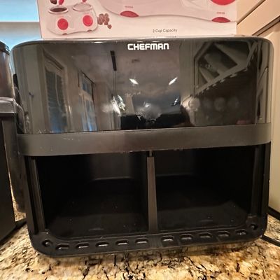Sale Photo Thumbnail #42: Black modern Chefman dual-basket air fryer unit, missing its removable frying baskets, displayed on a granite countertop.
