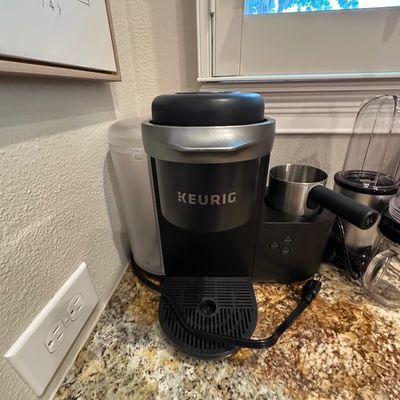 Sale Photo Thumbnail #47: Keurig K-Café single-serve coffee maker with integrated milk frother, set on a kitchen countertop.