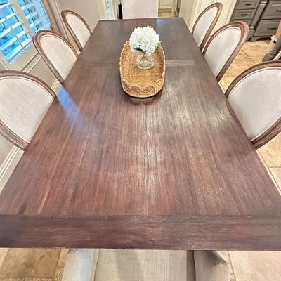 Sale Photo Thumbnail #49: Large dark wood dining table set with eight upholstered chairs, including oval-back side chairs and armchair ends, featuring a woven tray centerpiece.