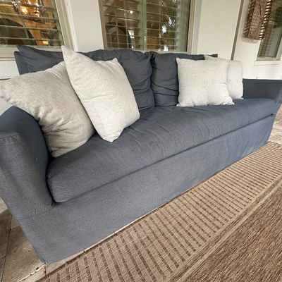 Sale Photo Thumbnail #23: Contemporary outdoor or patio sofa in charcoal blue fabric, styled with four light beige throw pillows.