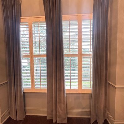 Sale Photo Thumbnail #102: Set of grey velvet floor-length curtain drapes paired with a brass curtain rod over white plantation shutters.