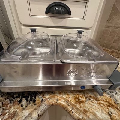 Sale Photo Thumbnail #43: Crux Artisan Series dual buffet server and warming tray with clear domed lids, sitting on a granite countertop.