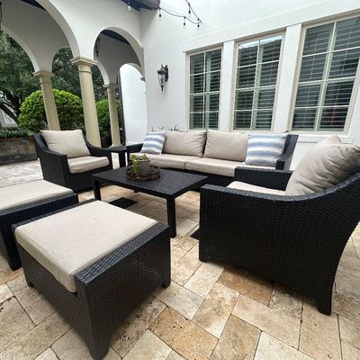 Sale Photo Thumbnail #18: Contemporary dark espresso resin wicker patio furniture set, including a three-cushion sofa, armchair, two ottomans, and a coffee table with neutral beige cushions.