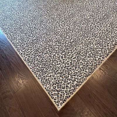 Sale Photo Thumbnail #30: Large area rug with a leopard print pattern, featuring beige, brown, and black tones on dark hardwood flooring.