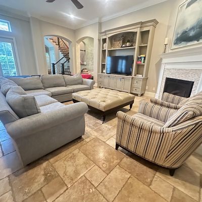 Sale Photo Thumbnail #88: Spacious living room set including a large light gray sectional sofa, a tufted cream leather ottoman, and a pair of striped armchairs.
