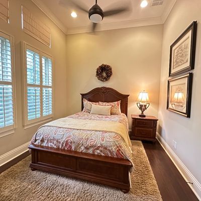 Sale Photo Thumbnail #121: Traditional wood bed frame with matching nightstand, paired with a patterned comforter and framed wall art in a decorated bedroom.