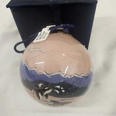 Sale Photo Thumbnail #285: Hand-painted glass sphere Christmas ornament featuring an orca whale and mountain landscape motif, displayed with its original dark navy box.