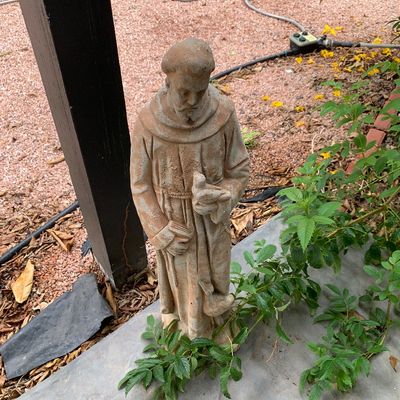 Sale Photo Thumbnail #43: Weathered concrete garden statue of Saint Francis holding a bird, featuring a distressed terra cotta finish.