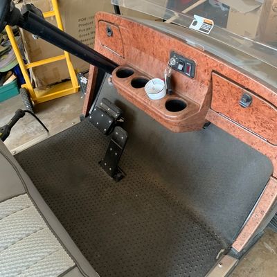 Sale Photo Thumbnail #50: Custom golf cart interior featuring a wood-grain patterned dashboard, cup holders, keys in the ignition, textured floor mat, and patterned vinyl seating.