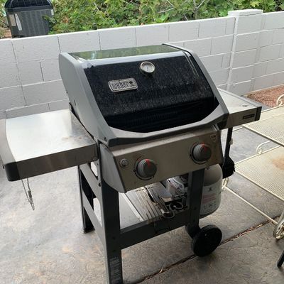 Sale Photo Thumbnail #37: Weber Spirit II two-burner liquid propane gas grill with side folding shelves and a built-in lid thermometer.