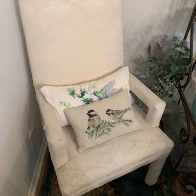 Sale Photo Thumbnail #12: High-back upholstered armchair in cream patterned fabric, paired with two bird-themed lumbar accent pillows.