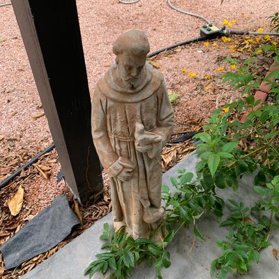 Sale Photo Thumbnail #44: Weathered concrete garden statue of St. Francis of Assisi holding a bird, depicting a traditional outdoor religious figure with an aged patina.