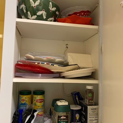 Sale Photo Thumbnail #32: Kitchen cabinet shelves filled with holiday-themed serving bowls, stacked plates, and various pantry items including instant coffee and salt.