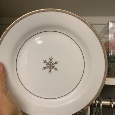 Sale Photo Thumbnail #115: White porcelain holiday accent plate featuring a central metallic snowflake motif and a matching patterned border.