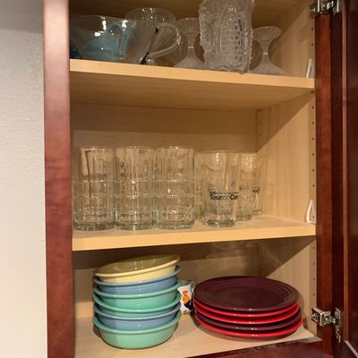 Sale Photo Thumbnail #20: Kitchen cabinet filled with glassware, cut crystal pieces, and colorful Fiesta dishware.
