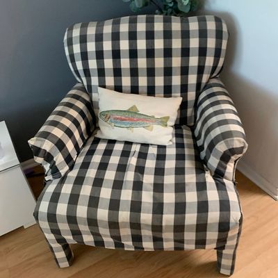 Sale Photo Thumbnail #3: Black and white buffalo plaid armchair paired with a white accent pillow featuring an embroidered fish.