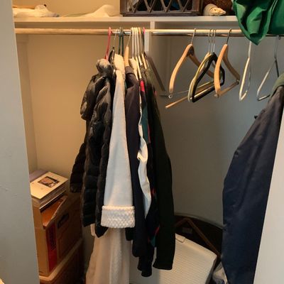 Sale Photo Thumbnail #88: Selection of coats and jackets hanging inside a bedroom closet alongside empty clothes hangers and stored boxes.