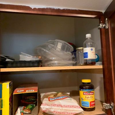 Sale Photo Thumbnail #23: Wooden kitchen cabinet filled with various food items, plastic storage containers, and dietary supplements.
