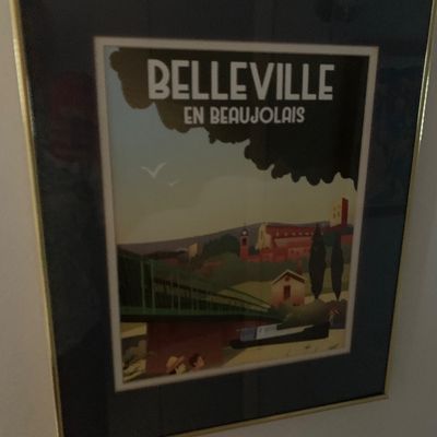 Sale Photo Thumbnail #92: Framed travel poster print featuring Belleville en Beaujolais, presented in a thin gold metal frame with a dark matte board.
