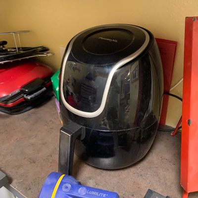 Sale Photo Thumbnail #28: Black PowerXL air fryer sitting on a countertop next to a blue Lumilite flashlight.