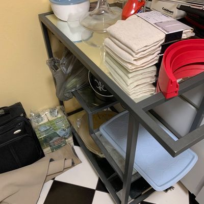 Sale Photo Thumbnail #30: Modern rolling bar cart with metal frame and mirrored shelves, loaded with various kitchenware, linens, and household goods.