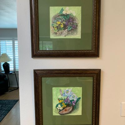 Sale Photo Thumbnail #16: Pair of framed botanical watercolor prints featuring colorful wildflower arrangements, displayed in matching dark wood textured frames with olive green matting.