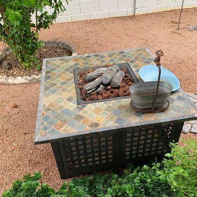 Sale Photo Thumbnail #41: Square outdoor slate tile propane fire pit table with faux log set and dark metal lattice base.