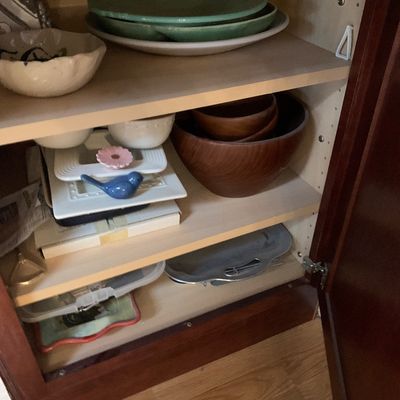 Sale Photo Thumbnail #79: Selection of kitchenware, ceramic dishes, and wooden salad bowls arranged inside a wooden cabinet.