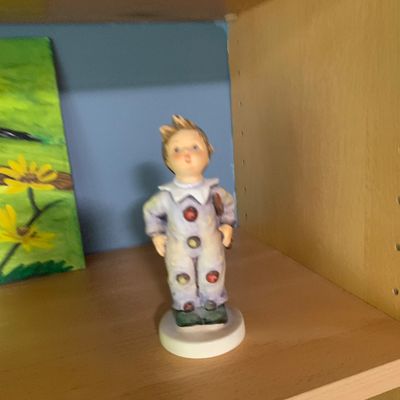 Sale Photo Thumbnail #74: Vintage Goebel Hummel porcelain figurine depicting a young boy in a harlequin clown costume.