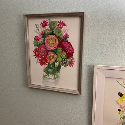Sale Photo Thumbnail #122: Framed watercolor painting of a colorful floral arrangement in a glass vase, presented in a grey wood-grain frame.