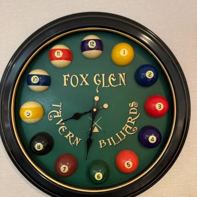 Sale Photo Thumbnail #18: Billiards-themed novelty wall clock with miniature pool ball hour markers and a green felt face reading 'Fox Glen Tavern Billiards'.