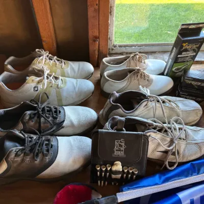 Sale Photo Thumbnail #38: Assortment of men's golf shoes including FootJoy models, paired with golf accessories like a tee holder, ball monogrammer, and Taylormade RBZ golf balls.