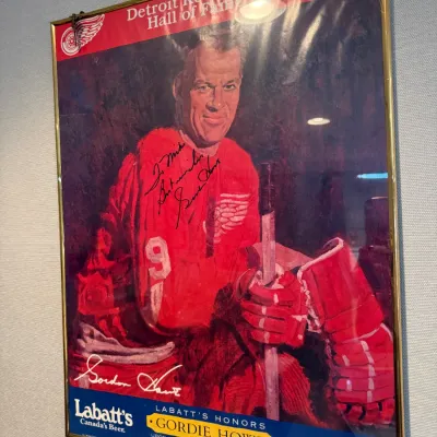 Sale Photo Thumbnail #27: Autographed Gordie Howe Detroit Red Wings Hall of Fame poster sponsored by Labatt's Beer, dated November 21, 1984, presented in a thin gold metal frame.