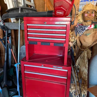 Red Craftsman two-piece rolling tool chest combo, topped with a red Toro electric leaf blower.