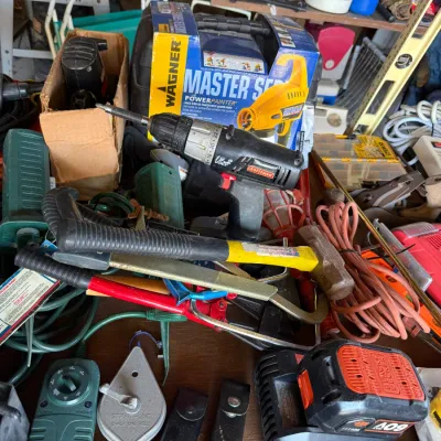 Assorted workshop tools and hardware including a Craftsman cordless drill, hammers, a Wagner paint sprayer in box, chalk line, and Black...