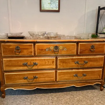Sale Photo Thumbnail #22: French Provincial style light wood dresser featuring seven drawers with floral stencil detail, cabriole legs, and brass hardware.