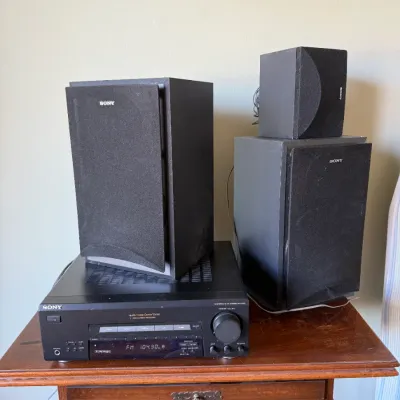 Sale Photo Thumbnail #17: Sony audio/video control center receiver paired with three Sony speakers featuring black mesh grilles, sitting on a wooden table.