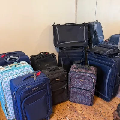 Collection of modern rolling suitcases and garment bags in various colors and geometric patterns.