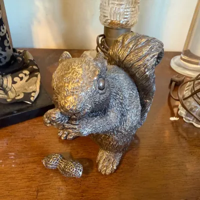 Heavy silver-tone cast metal squirrel figurine holding an acorn, accompanied by a small matching metal peanut.