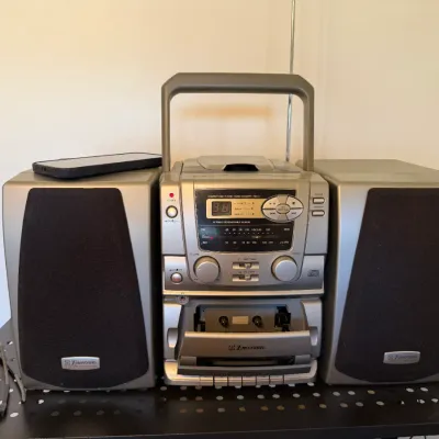 Emerson silver portable stereo system featuring a top-loading CD player, AM/FM radio, cassette deck, and detachable speakers, circa late...