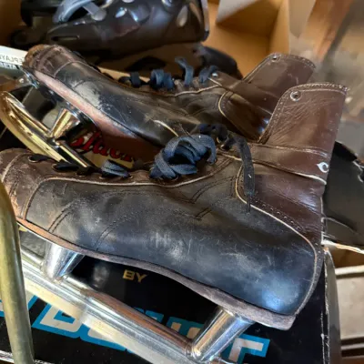 Sale Photo Thumbnail #30: Vintage leather speed skates with metal runners showing wear and patina from use.