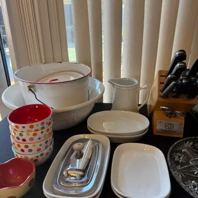 Collection of kitchenware featuring a Calphalon wooden knife block set, ceramic polka dot bowls, white serving dishes, a stainless steel...