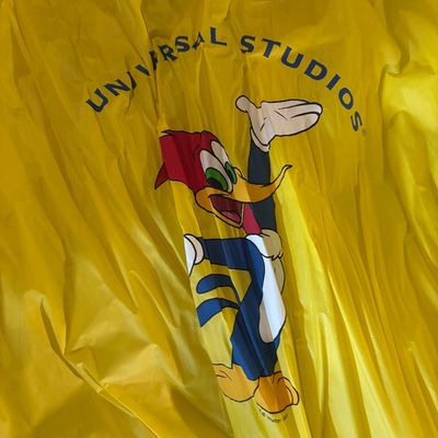 Sale Photo Thumbnail #126: Vintage yellow Universal Studios rain poncho featuring a large graphic of Woody Woodpecker.