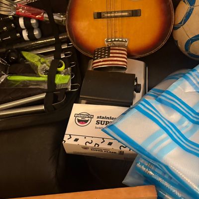 Sale Photo Thumbnail #51: Collection of assorted household items, including a vintage sunburst acoustic guitar body, a grill tool set in a black case, and novelty flasks.