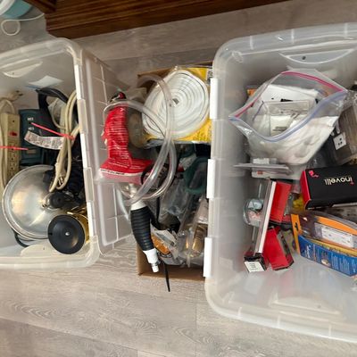 Sale Photo Thumbnail #29: Two clear plastic storage totes and a cardboard box filled with various home improvement items, including extension cords, power strips, clear tubing, and electrical supplies.