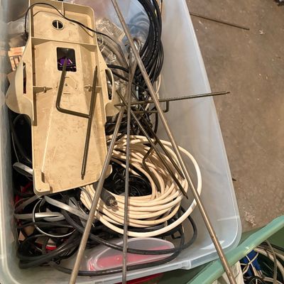 Sale Photo Thumbnail #111: Clear plastic storage tote filled with assorted electronic cables, wire antennas, and plastic housing components.