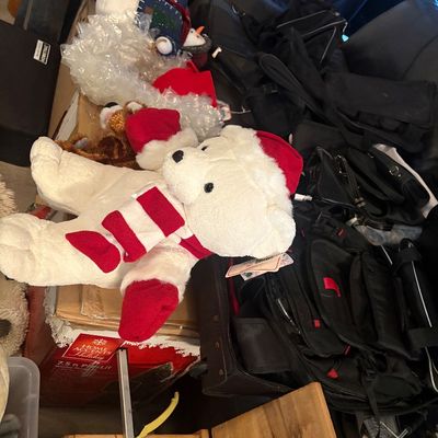 Sale Photo Thumbnail #49: Plush holiday polar bear with a Santa hat and red-and-white striped scarf, resting atop a pile of bags and holiday decor.