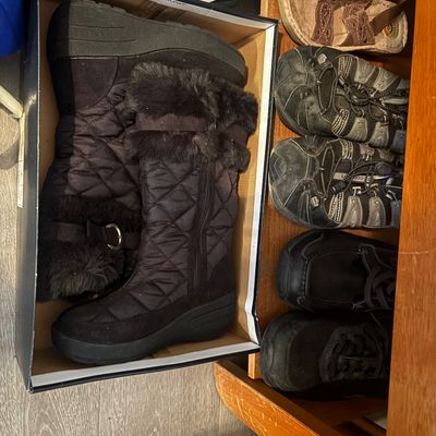 Sale Photo Thumbnail #70: Collection of women's shoes and boots, including a pair of black faux-fur trimmed quilted winter boots in their original box alongside athletic shoes and sandals.