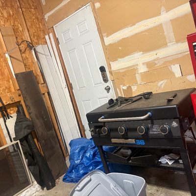 Sale Photo Thumbnail #3: Black Pit Boss four-burner flat-top griddle with cover alongside a red Snap-on rolling tool chest in a garage workshop.
